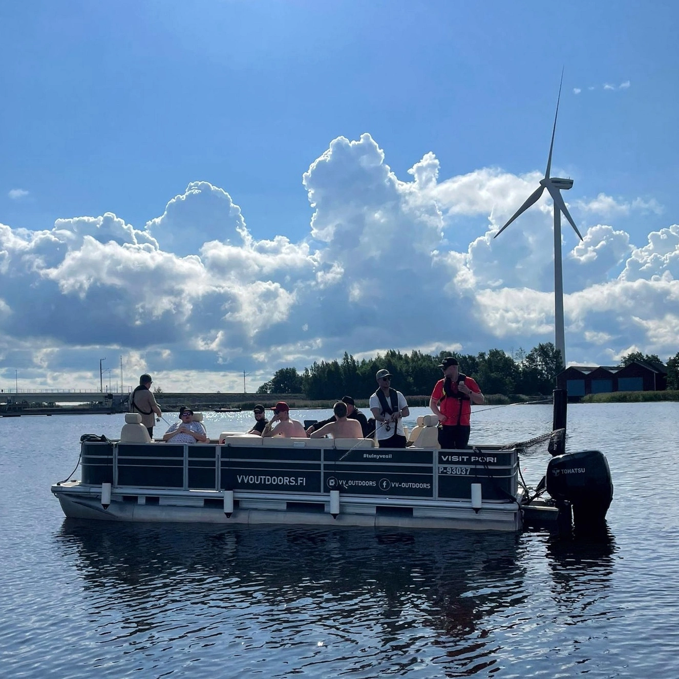 Ryhmä kalastamassa Trapper Pontoon -veneellä tuulivoimalan edessä