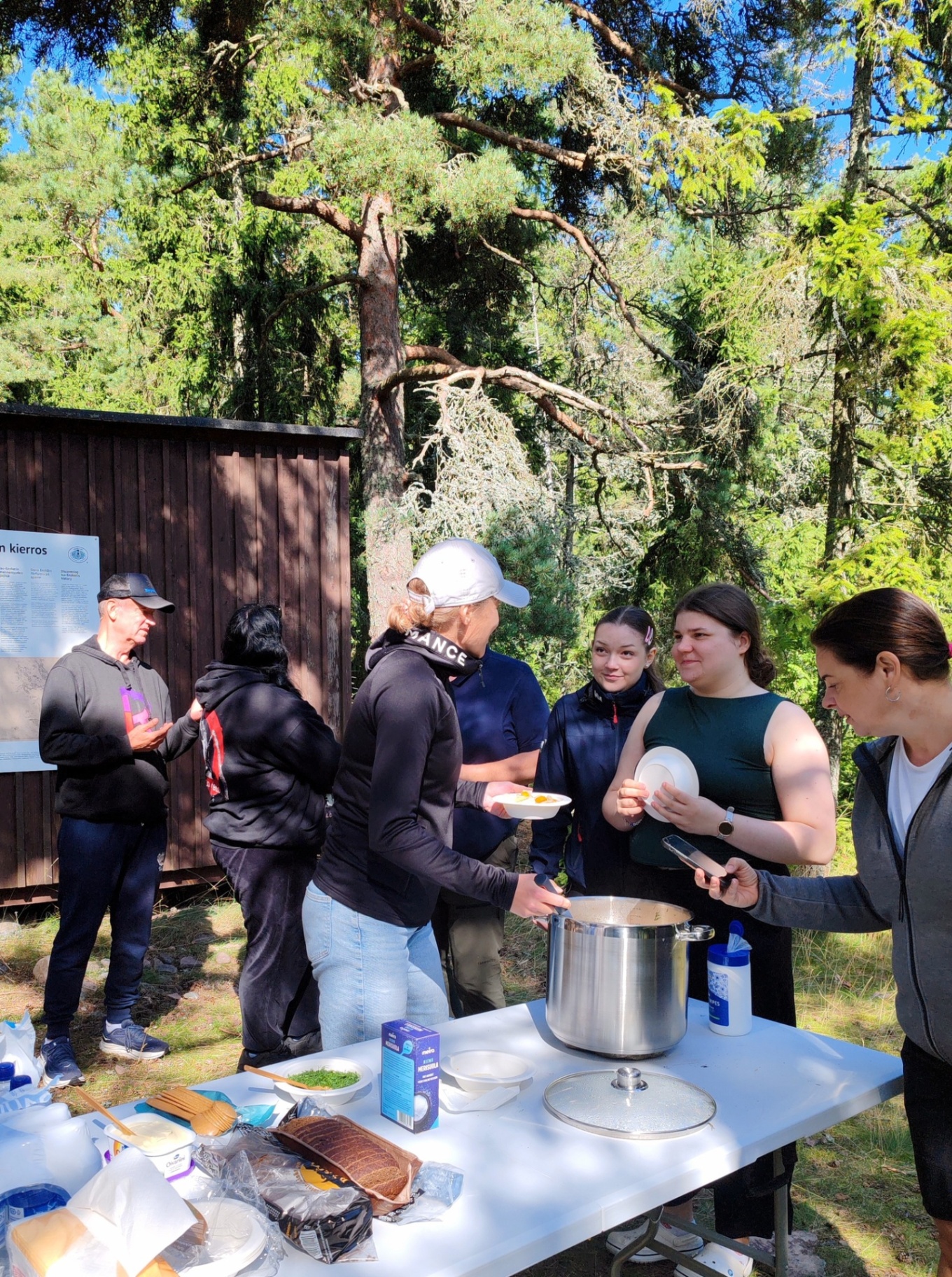Yhteinen retkiruokailu saaressa metsän siimeksessä